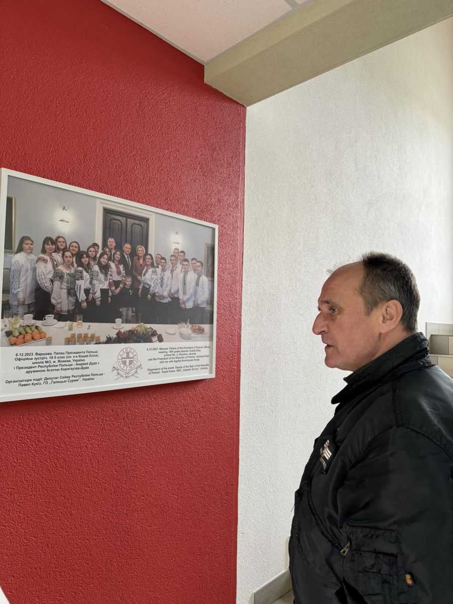 Павел Кукіз дивиться на памʼятне фото, де учні з Жовкви сфотографувалися з президентом Польщі Анджеєм Дудою і його дружиною. Цю поїздку він організував і профінансував.